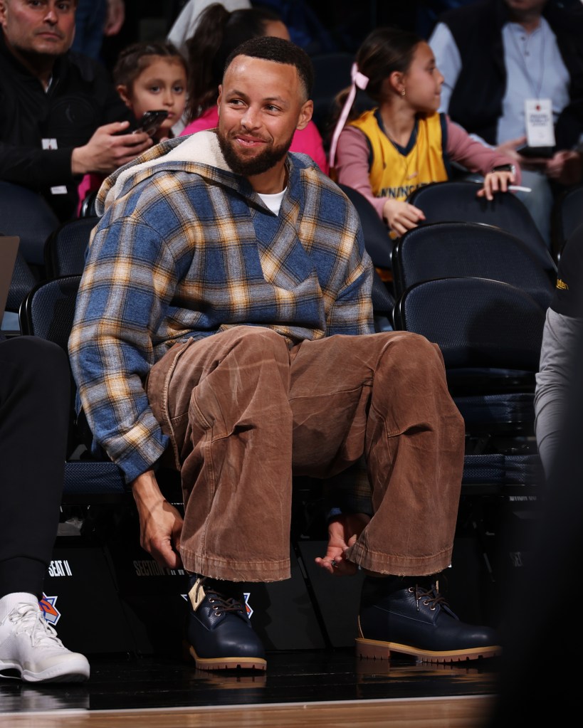 Ste[hen Curry wathces on from the bench during the Warrioprs-Knicks game on March 15, 2026. 