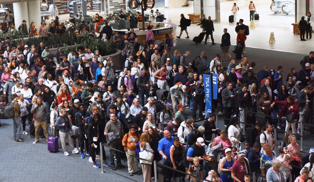 Travelers wait in a TSA security line at Orlando International Airport during a partial government shutdown.