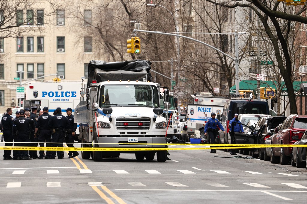 NYPD bomb squad officers investigate a suspicious device in a car.