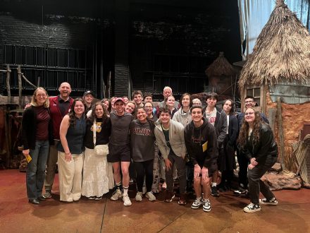 Group standing on Broadway stage taking photo with Andrew Stevens Purdy ‘20.