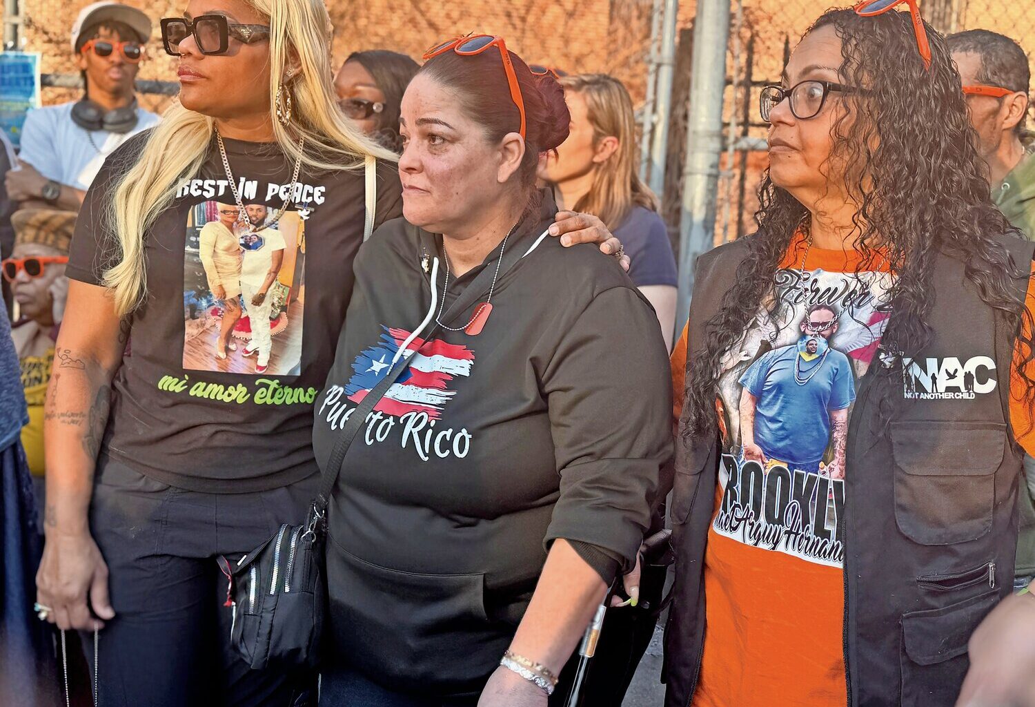 During the rally, Alexandra Diaz, left, who lost her son to gun violence last year embraced Carmen Ramos, center, whose brother was also fatally shot in 2025. Marisol Miranda, right, whose son was stabbed to death by a teen last year, stood beside them.