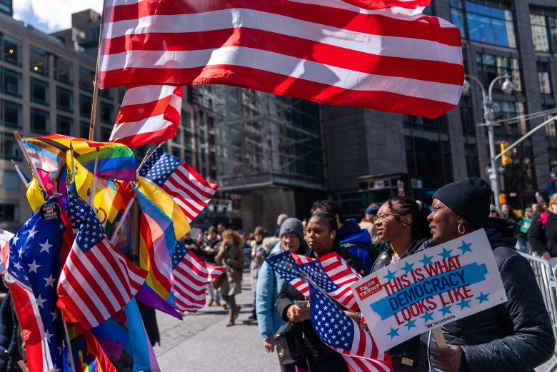 Protestors look at flags for sale from a vendor at Central Park South in Manhattan on Saturday, March 28, 2026. Photo by Allison Hunter for The Haitian Times.

