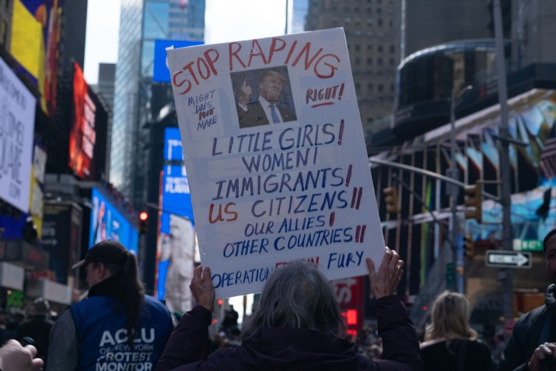 A protestor holds up a sign while marching in the No Kings Day event in Manhattan on Saturday, March 28, 2026. Photo by Allison Hunter for The Haitian Times.
