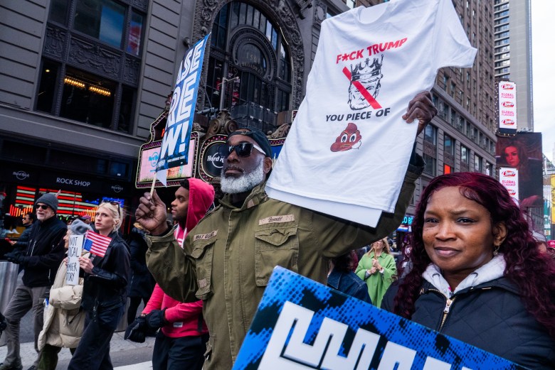 Protestors hold signs and T-shirts as they march in the No Kings Day event in Manhattan on Saturday, March 28, 2026. Photo by Allison Hunter for The Haitian Times.
