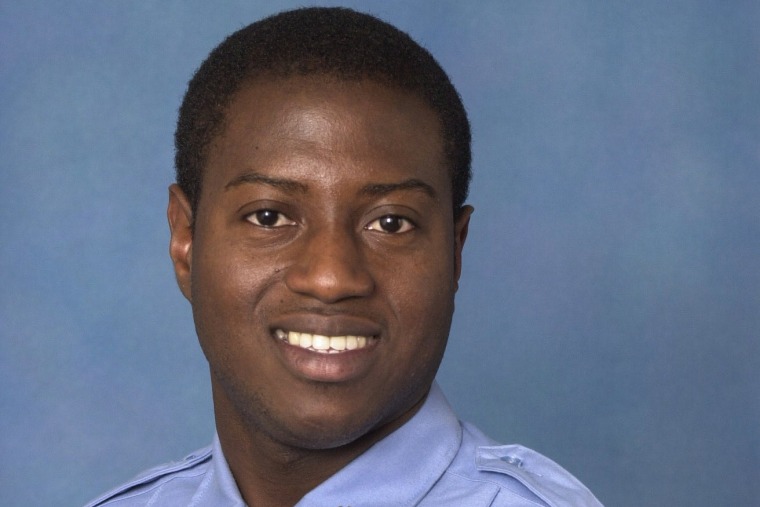 Sorffly Davius smiles for a portrait against a blue background
