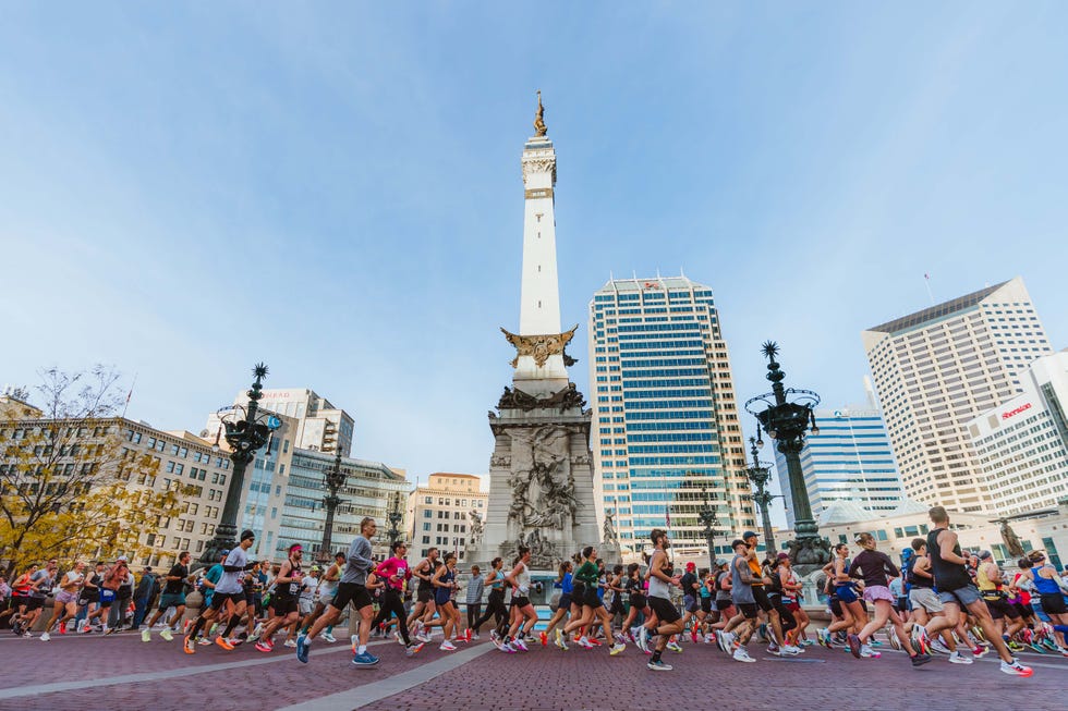Runners participating in an event near a historic monument and modern buildings.