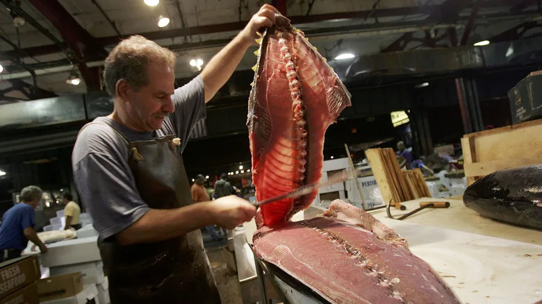 A worker fillets a large fish