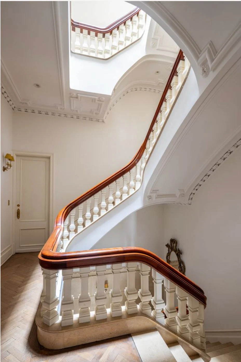The sweeping staircase of the House of Cassini spirals up toward its added sixth floor and skylight.