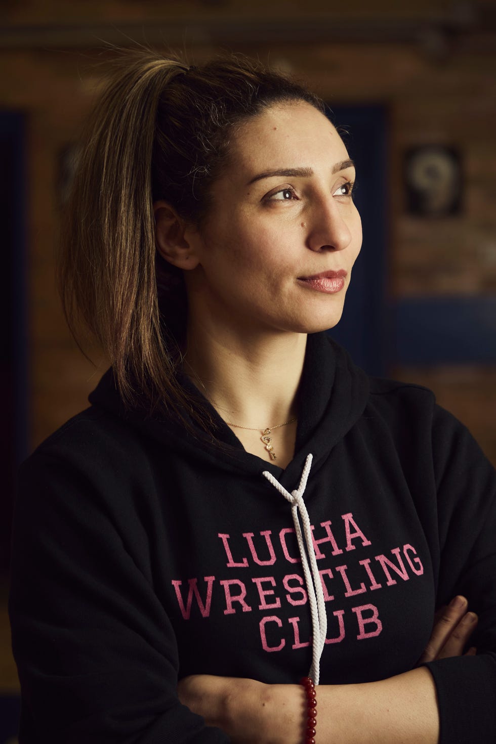 athlete in a black hoodie with lucha wrestling club written in pink
