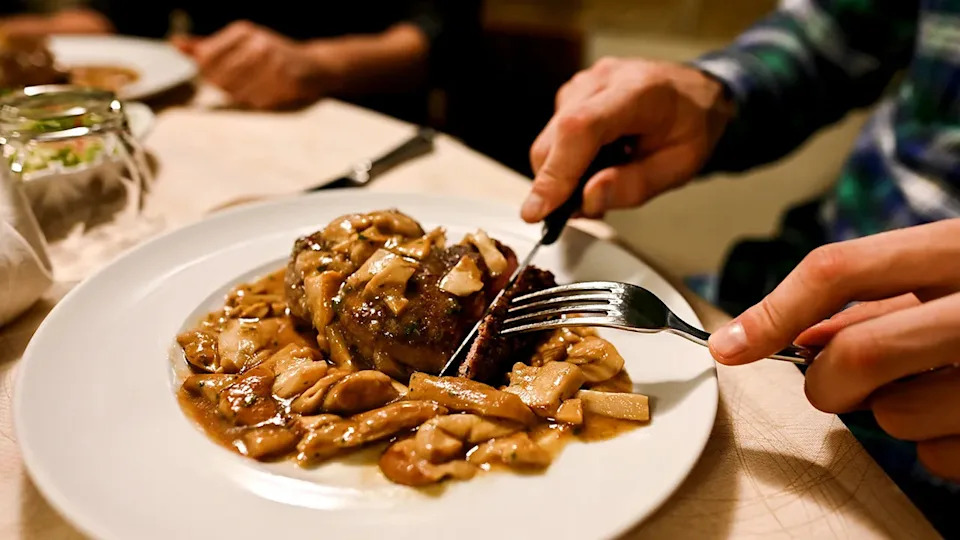 Eating mushrooms on a white plate in a restaurant close up shot
