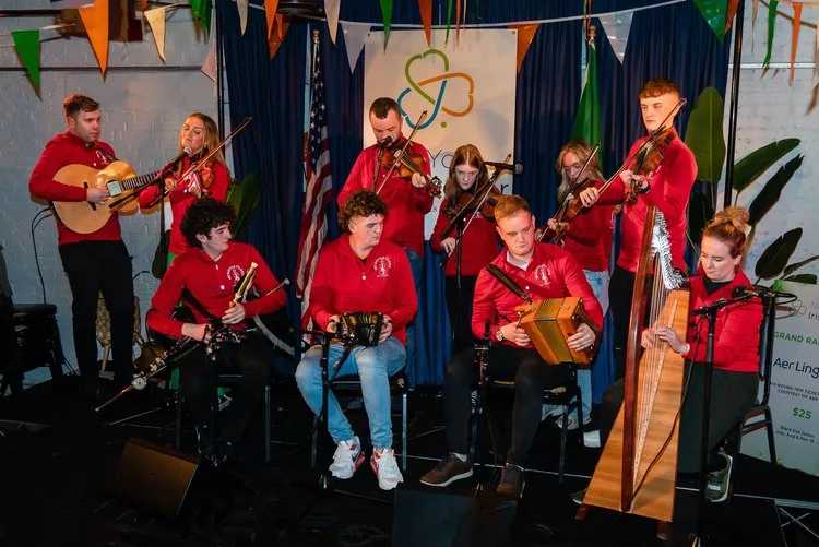 Music performers dressed in red shirts on stage.