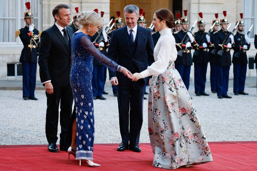 Brigitte Macron holds Queen Mary's hand at state dinner greeting