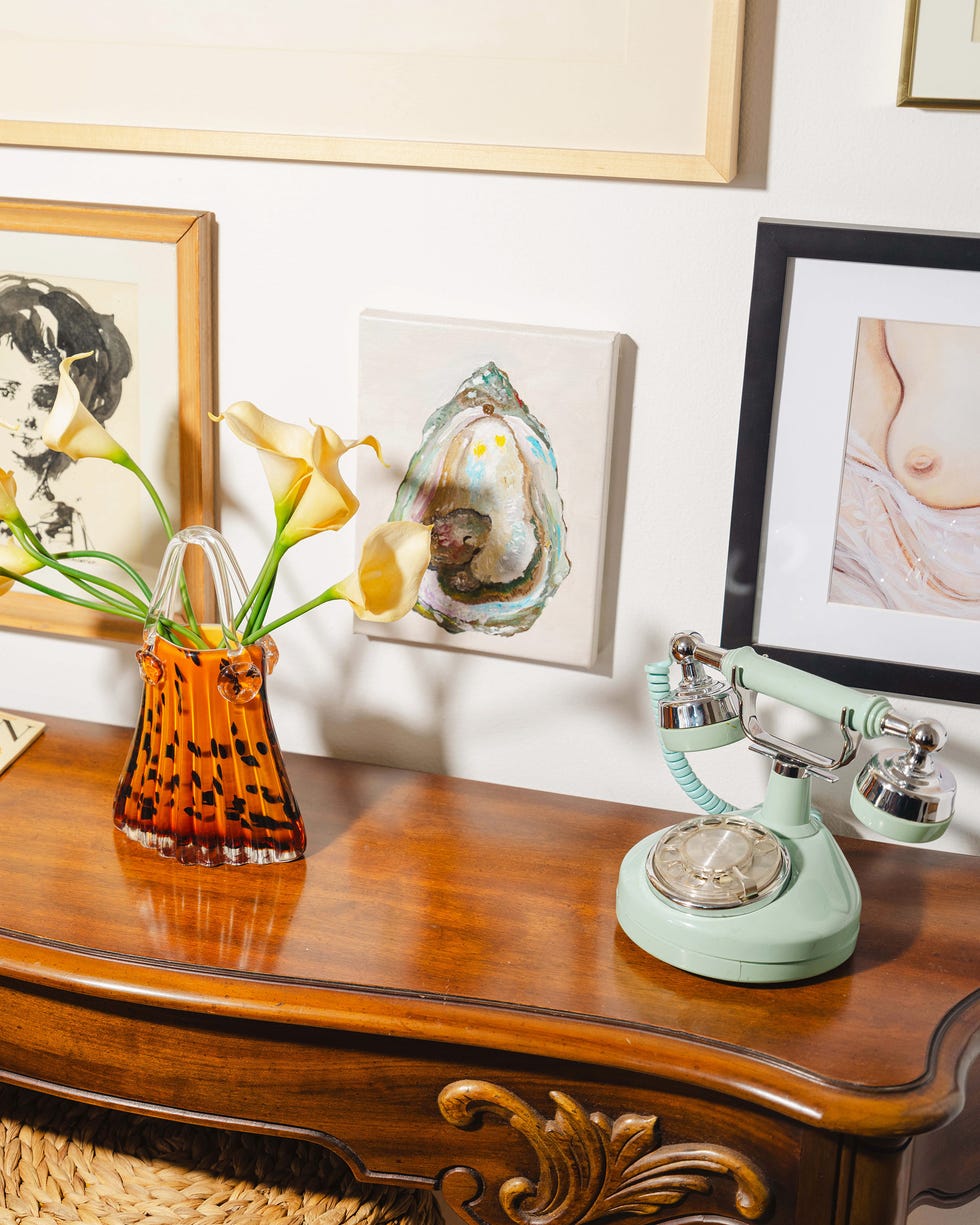 Decorative console table adorned with a vase and art pieces.