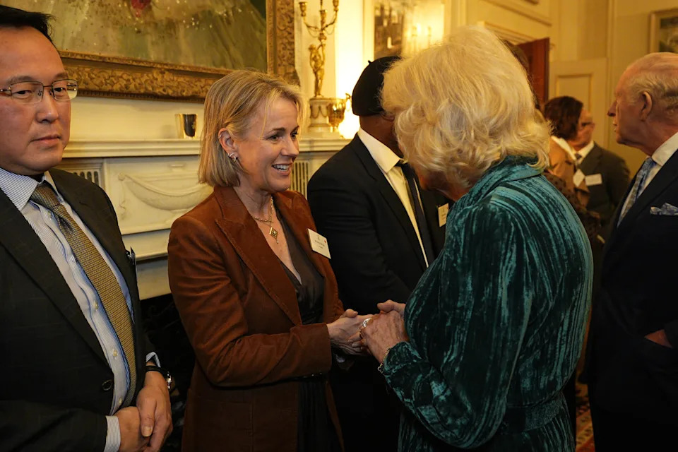Queen Camilla holding hands with Jojo Moyes