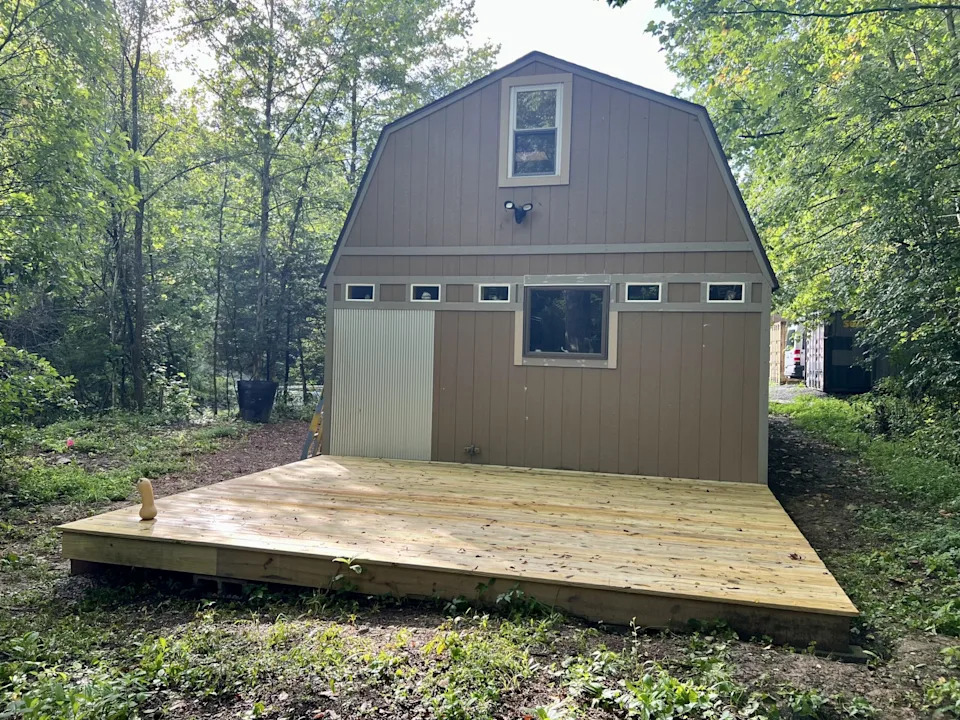 The backyard of this tiny home has a deck for entertaining. 