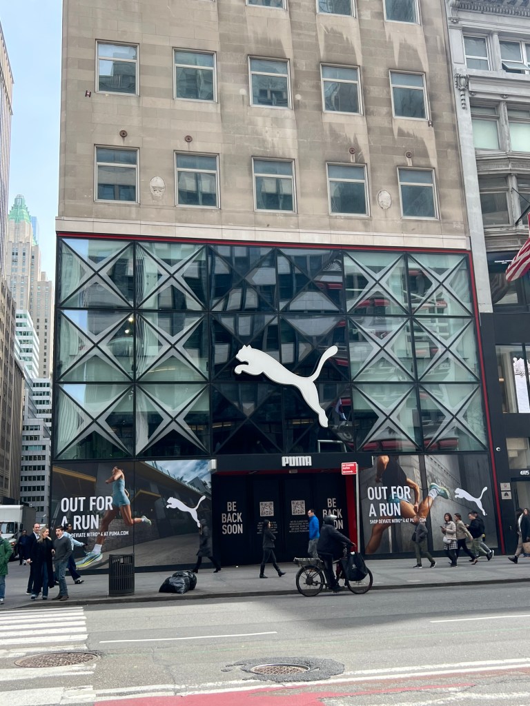 Exterior of the Puma store at 609 Fifth Ave, with a large Puma logo and "Out for a Run" advertisement.