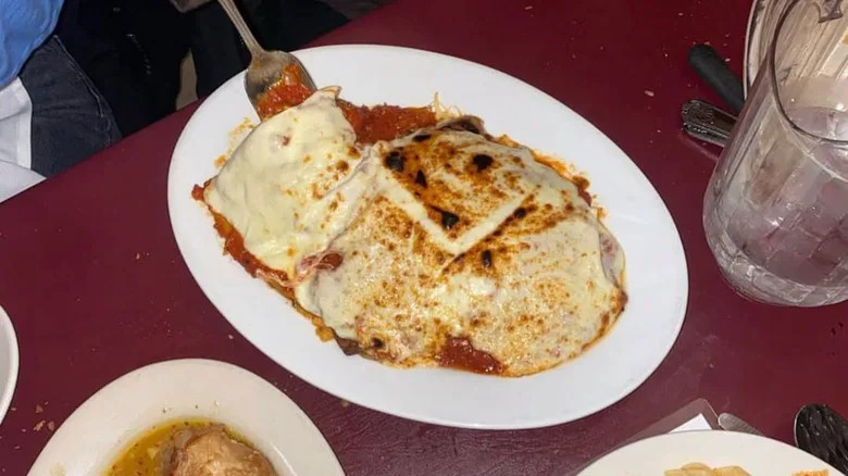 Veal parmigiana is served on a white plate.