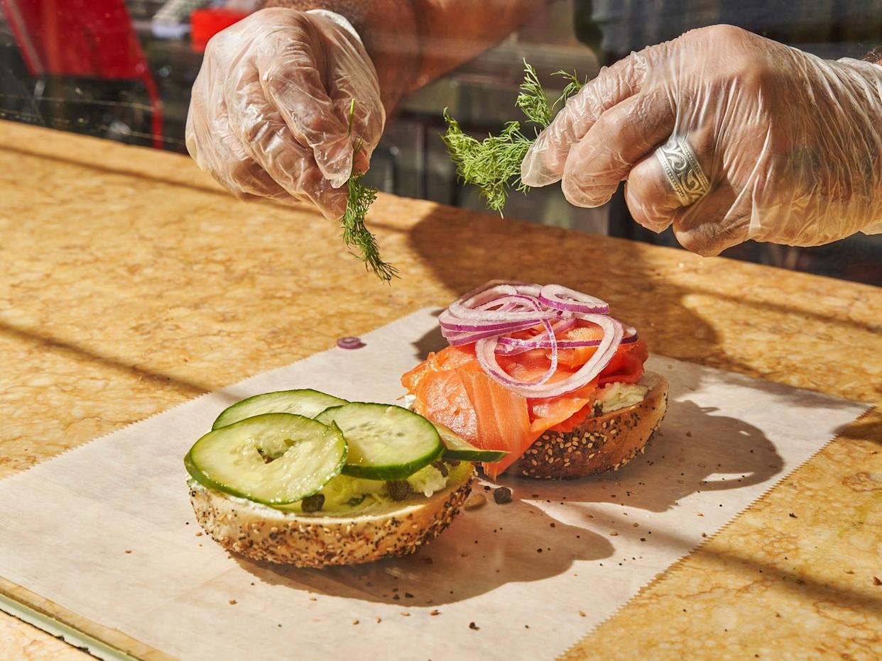 Ahmed Fadel prepares a smoked salmon and cream cheese everything bagel at Tompkins Square Bagels in Manhattan, Dec. 3, 2021. Supply chain problems that have hit businesses across the country now threaten a quintessential New York treat, with bagel purveyors scrambling to find and hoard as much cream cheese as they can.