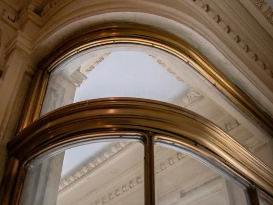 A closeup of the Cassini mansion vestibule shows its unusual, turn-of-the-century curve of marble, brass and glass.