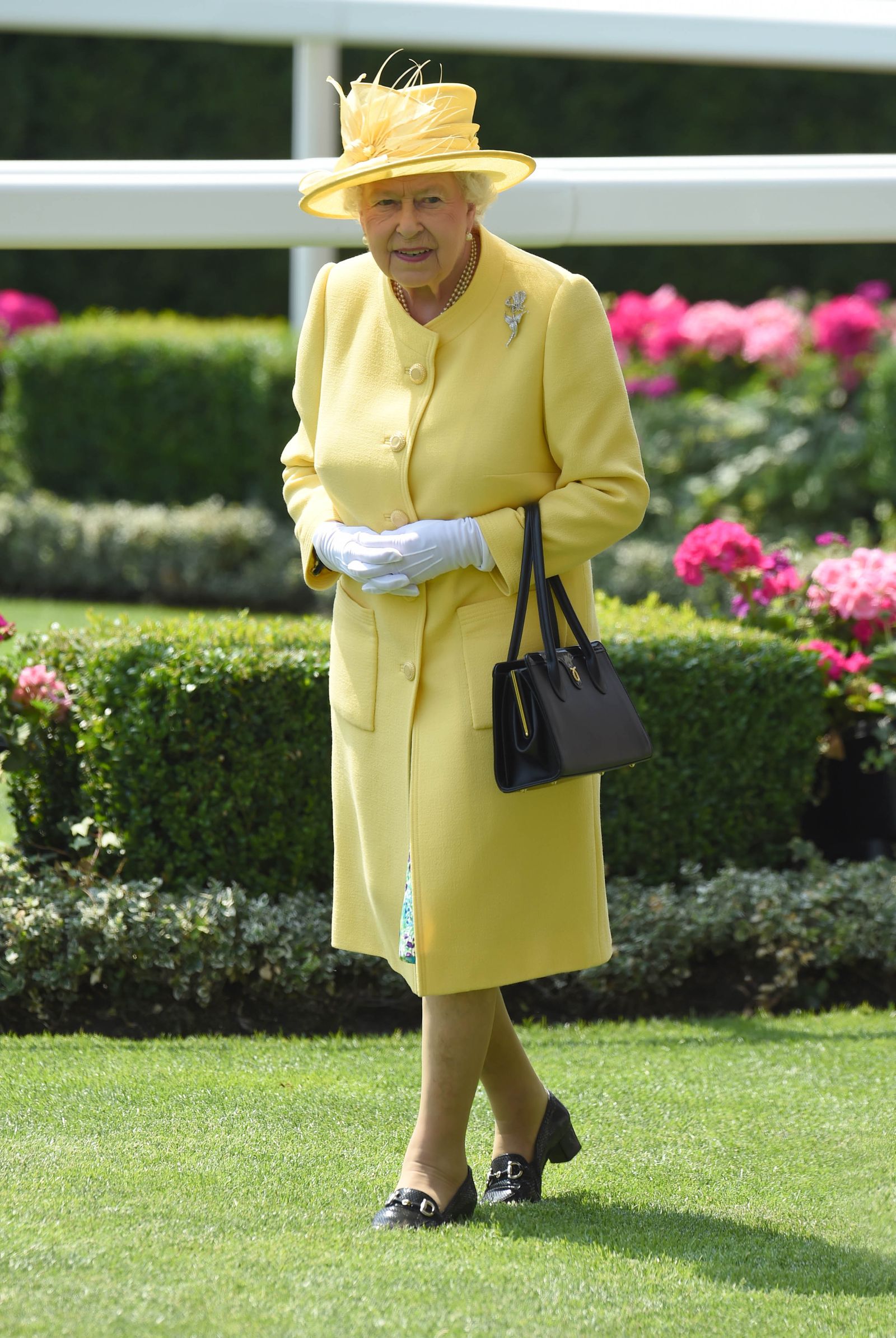 Image may contain Elizabeth II Person Adult Clothing Glove Accessories Bag Handbag Coat Hat Face and Head