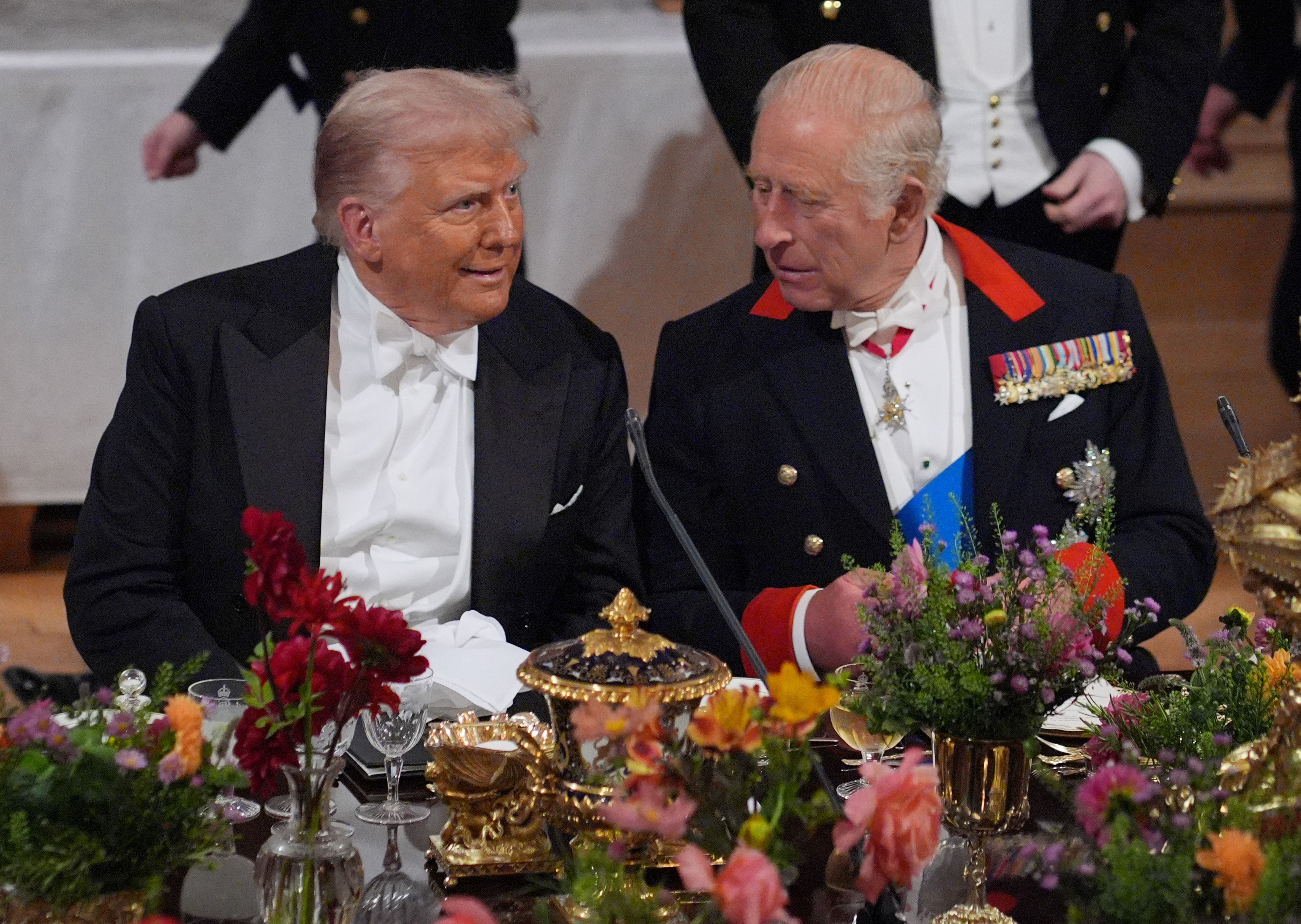 King Charles and Donald Trump in tuxedos sitting next to each other
