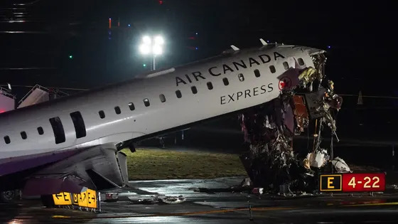 A plane sits on the runway surrounded by emergency equipment.
