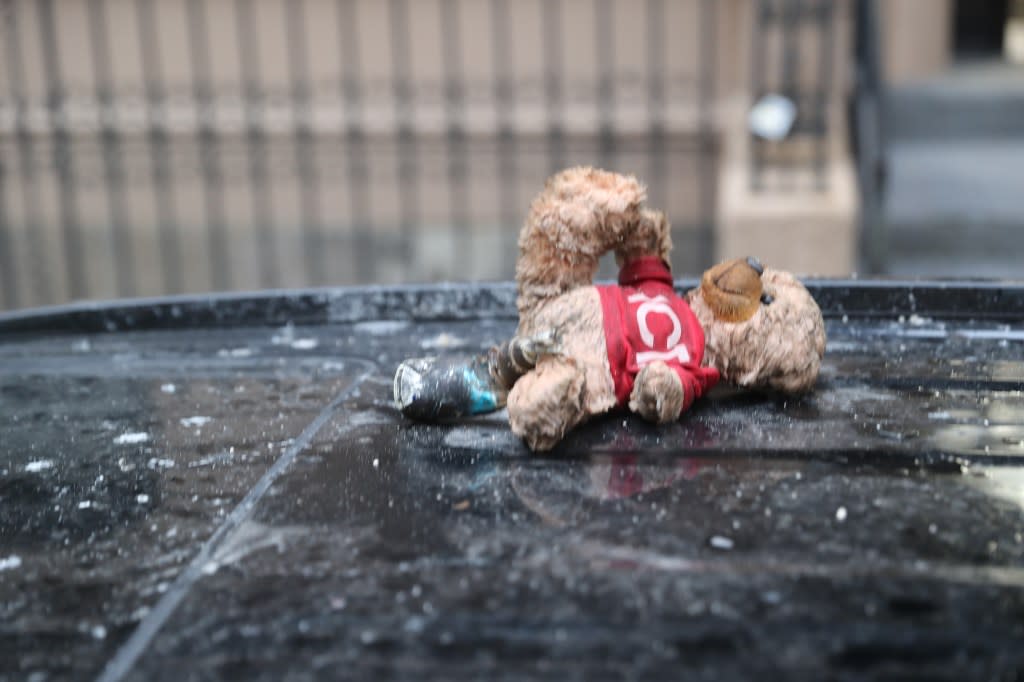 A teddy bear seen on top of a car in front of the building where the fire took place. William C Lopez/New York Post