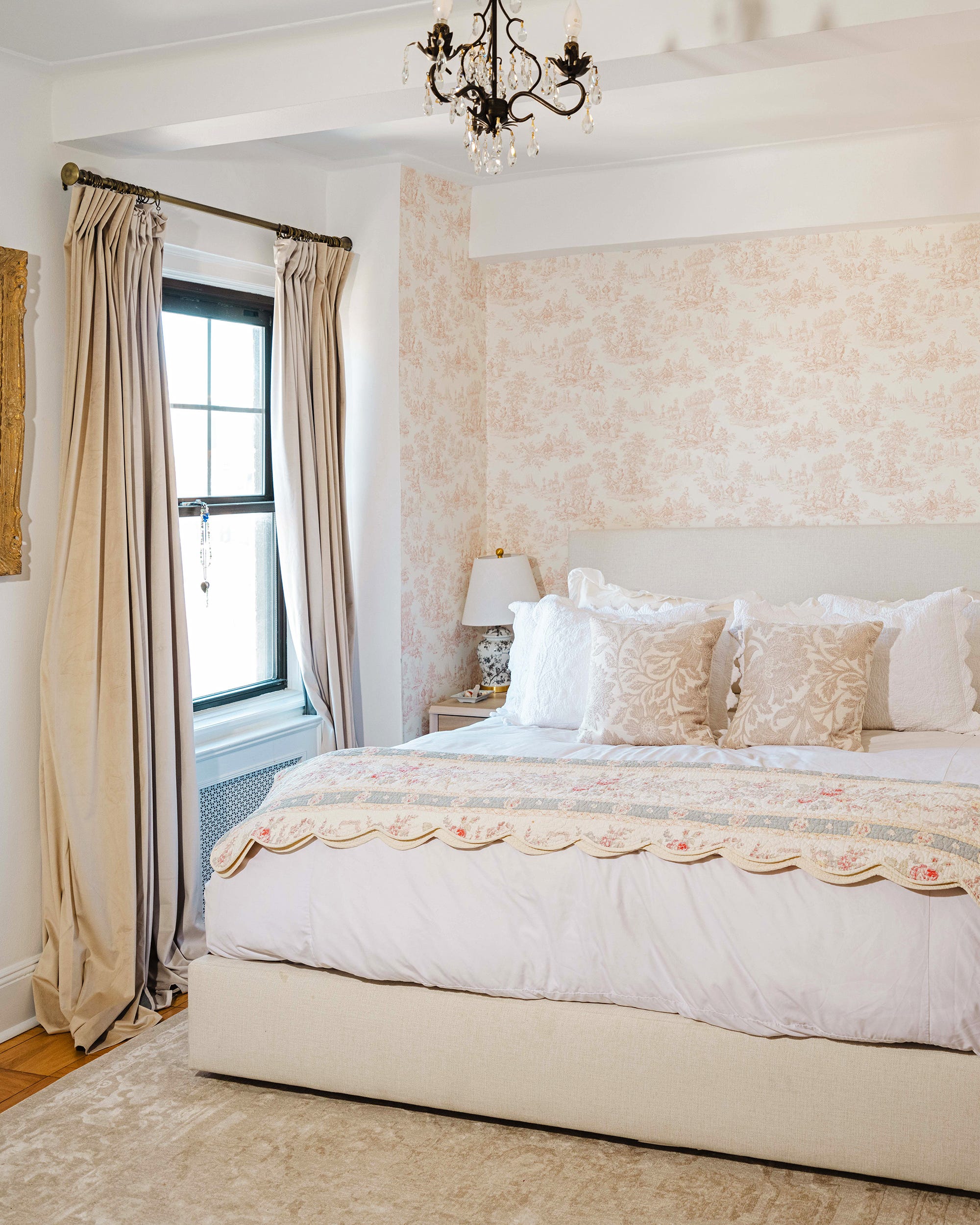 Cozy bedroom featuring a bed with decorative pillows and a warm ambiance.