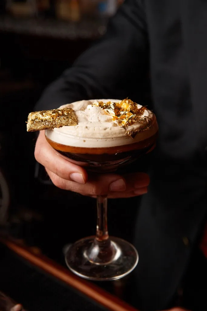 The Versailles Velour cocktail is topped with gold flake and an ingot of gilded logo chocolate. Tamara Beckwith/NY Post