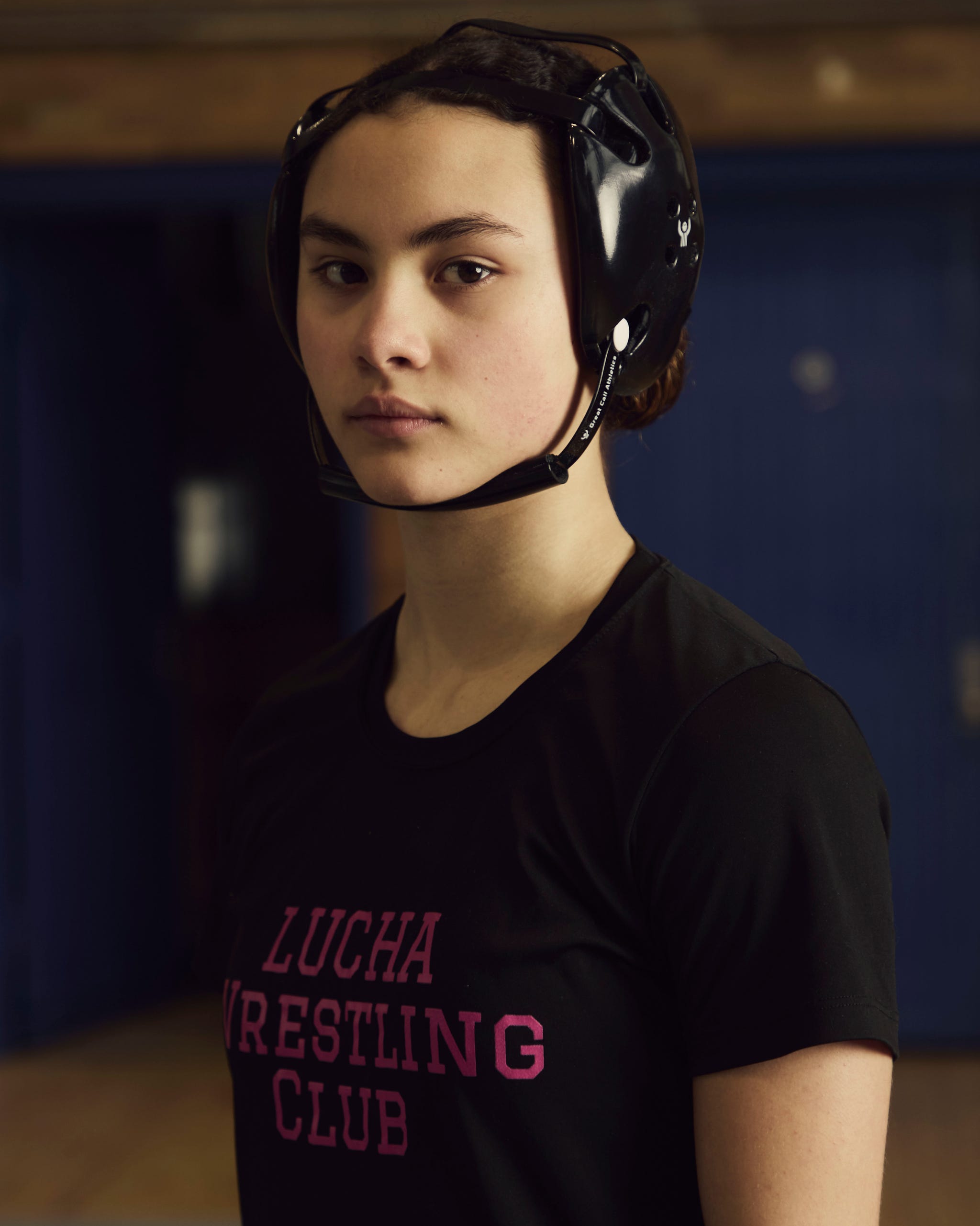individual in wrestling attire with headgear focused on wrestling activities