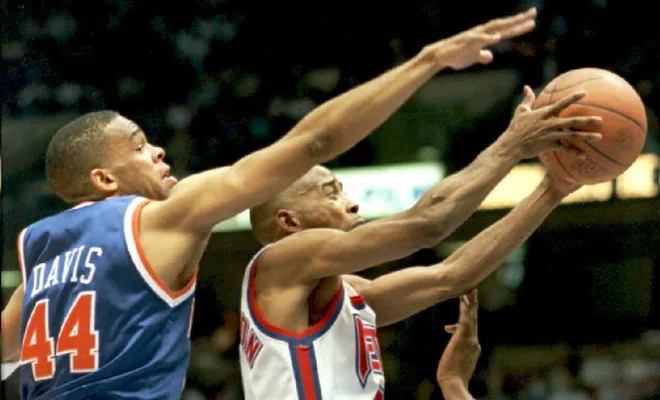 EAST RUTHERFORD, NJ - APRIL 2: New Jersey Nets Kenny Anderson slips under New York Knicks Hubert Davis (L) for a layup in the first half 02 April in East Rutherford, New Jersey. AFP PHOTO (Photo credit should read MARK PHILLIPS/AFP via Getty Images)