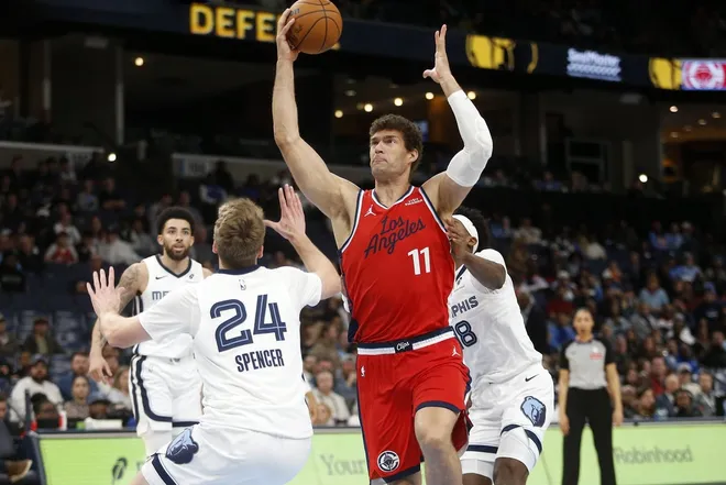 Mar 7, 2026; Memphis, Tennessee, USA; Los Angeles Clippers center Brook Lopez (11) drives to the basket as Memphis Grizzlies guard Cam Spencer (24) defends during the fourth quarter at FedExForum.