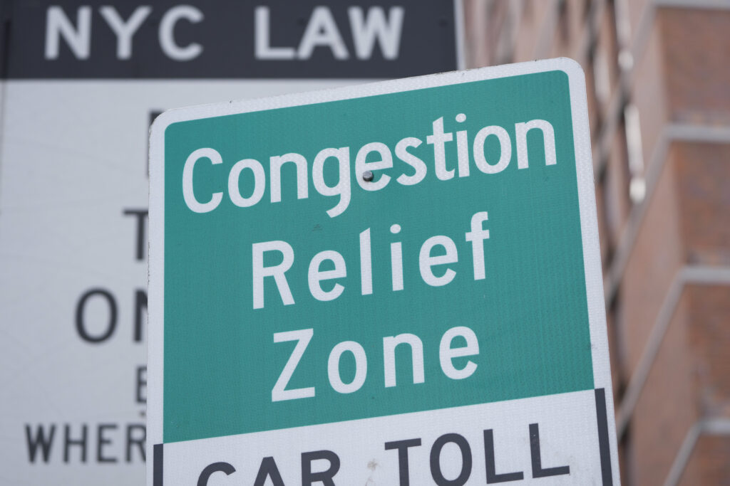 Signs, including some advising drivers of congestion pricing tolls, are displayed near the exit of the Lincoln Tunnel in New York, Wednesday, Feb. 19, 2025. AP Photo/Seth Wenig