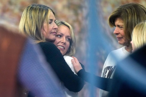 Savannah Guthrie, left, hugs Dylan Dreyer while Hoda Kotb looks on, during a visit to the Today show at Rockefeller Plaza on Thursday, March 5, 2026, in New York. (Photo by Charles Sykes/Invision/AP)