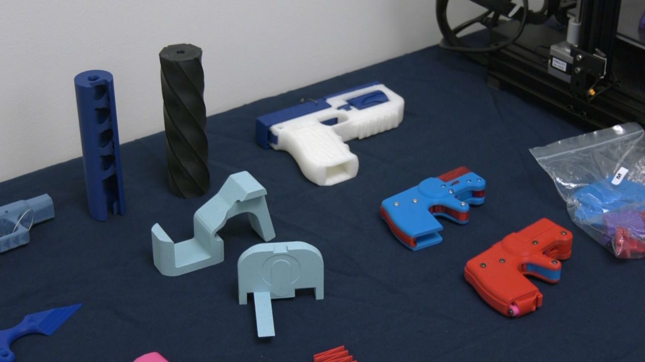 Manhattan District Attorney Alvin Bragg showed reporters Tuesday how a $250 printer and a few dollars worth of parts can transform an AR-15 rifle into a DIY machine gun. (Spectrum News NY1)
