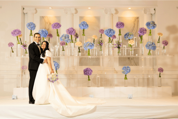 Couple Posing in front of Floral Arrangement