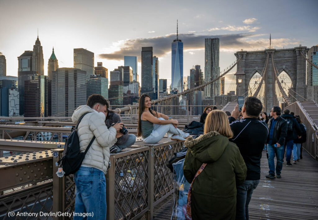 People posing for photographs on Brooklyn bridge (© Anthony Devlin/Getty Images)
