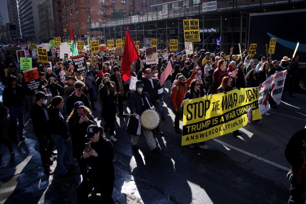 People hold signs during a "Stop the War on Iran" protest at Times Square on Saturday. 