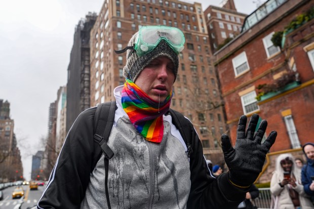A left-wing activist is seen after being pepper sprayed by a right-wing demonstrator at a protest organized by right-wing influencer Jake Lang on March 7, 2026 in New York City. (Photo by Ryan Murphy/Getty Images)