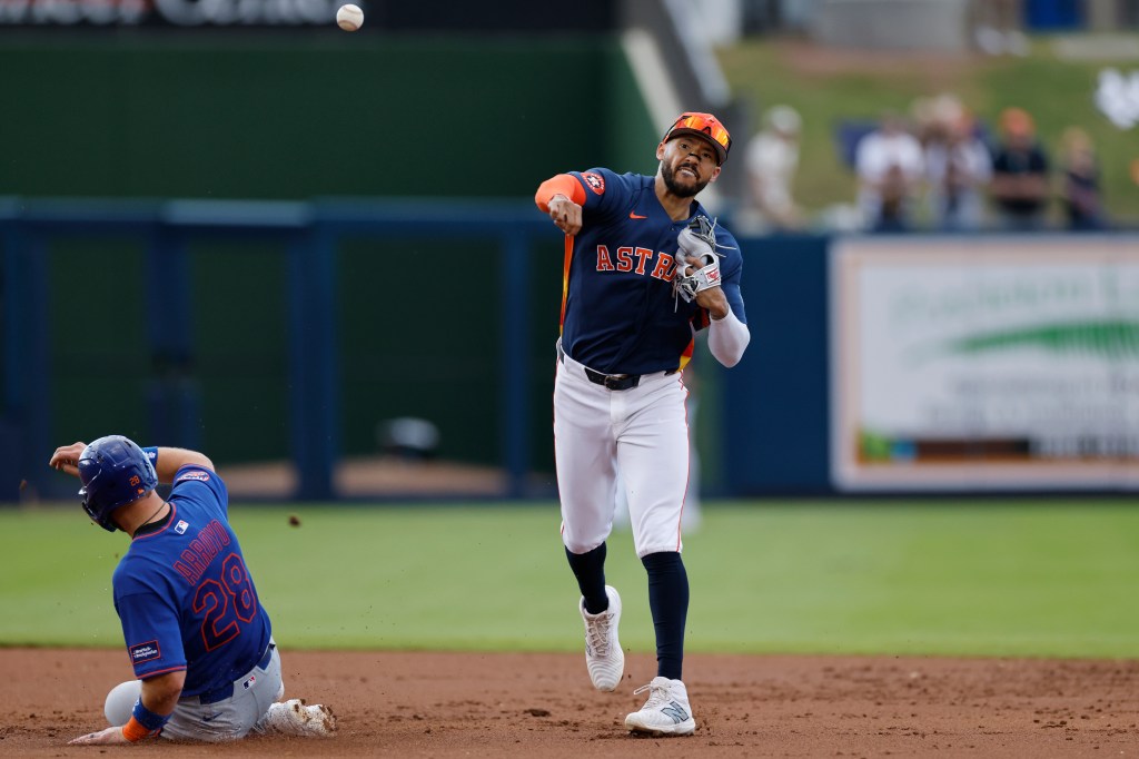 Carlos Correa (1) of the Houston Astros turns a double play over the slide by Christian Arroyo (28) of the New York Mets during a spring training game on March 14, 2026 at CACTI Park of the Palm Beaches in West Palm Beach, Florida. 