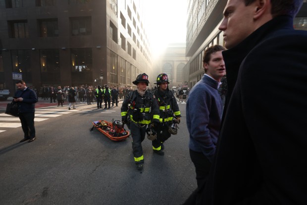 Firefighters from New York Fire Department (NYFD) work at the scene as fire and heavy smoke are seen at a high-rise building in Midtown Manhattan near the St. Patrick's Day Parade route in New York City on March 17, 2026. (Photo by TIMOTHY A.CLARY / AFP via Getty Images)