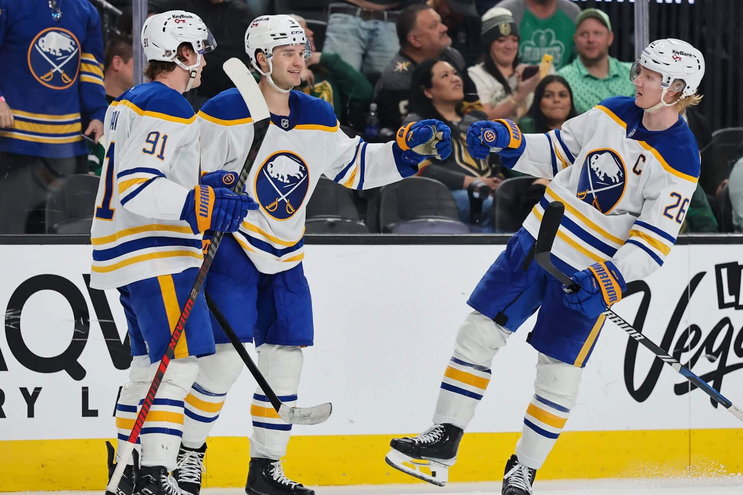 Josh Doan (91), Josh Norris (9) and Rasmus Dahlin (26) celebrate a goal.