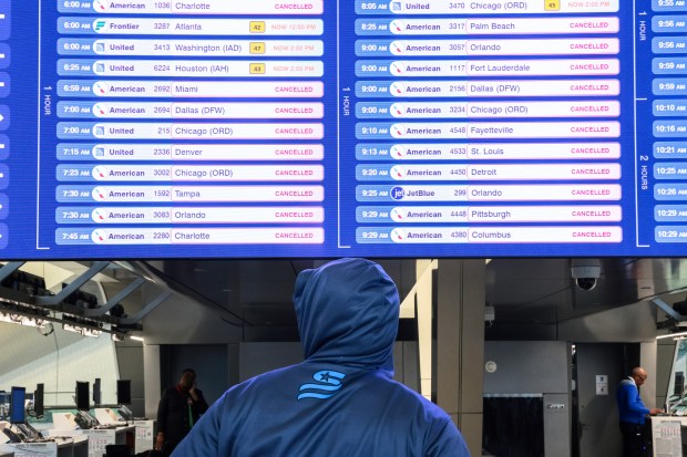 NEW YORK, NEW YORK - MARCH 23: A traveler looks at canceled flight schedules on a screen at Terminal B in LaGuardia Airport on March 23, 2026 in New York City. All flights into and out of LaGuardia airport have ben cancelled until 2 P.M. after an Air Canada Express plane flight from Montreal collided with a fire truck on the tarmac killing the pilot and leaving more than forty people injured. (Photo by Michael M. Santiago/Getty Images)