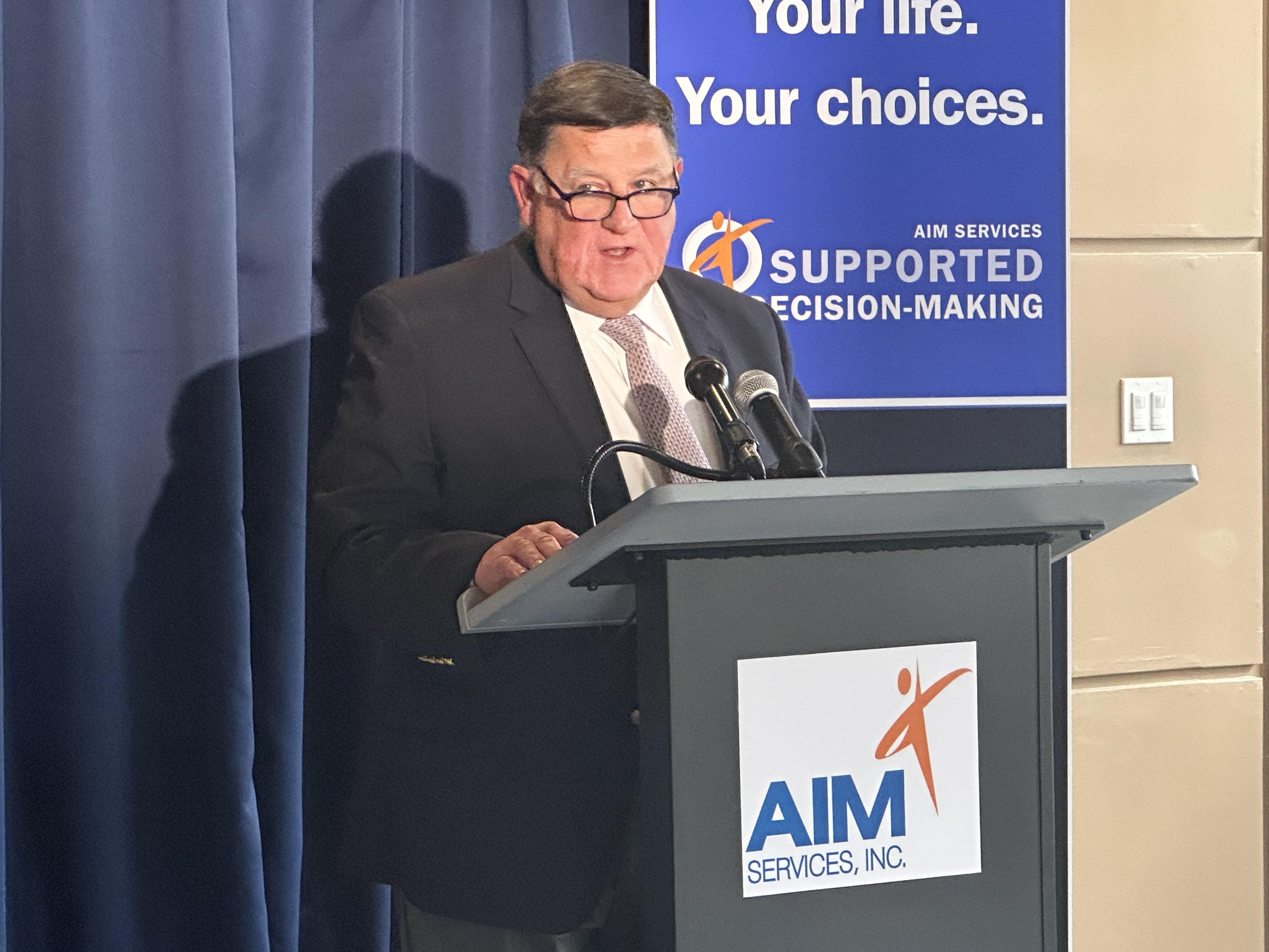 AIM Services Chief Executive Officer Chris Lyons spoke at the...