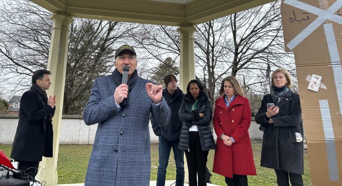 Village of Great Neck Mayor Pedram (C.) speaks at the Iran War demonstration in Great Neck.
