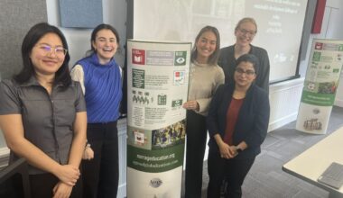 Students and educators pose near a poster