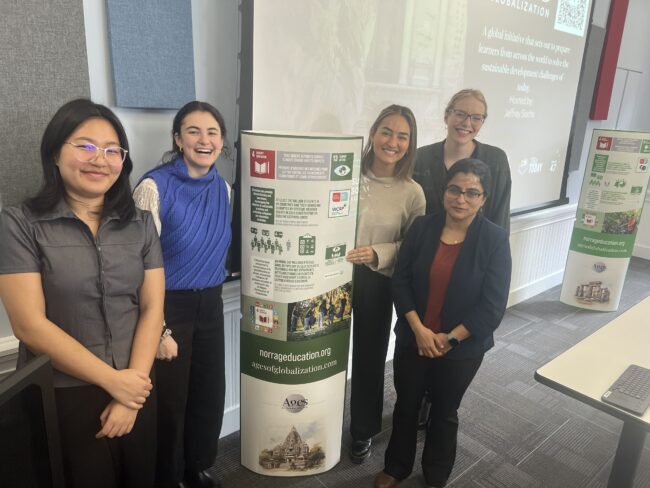 Students and educators pose near a poster