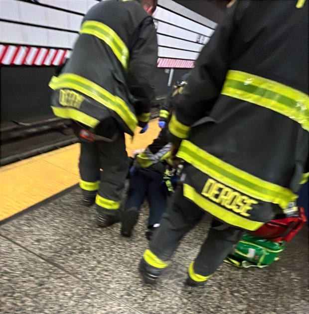 Richard Williams is tended to by FDNY firefighters after he was randomly shoved to the subway tracks. (Courtesy of Jhon Rodriguez)