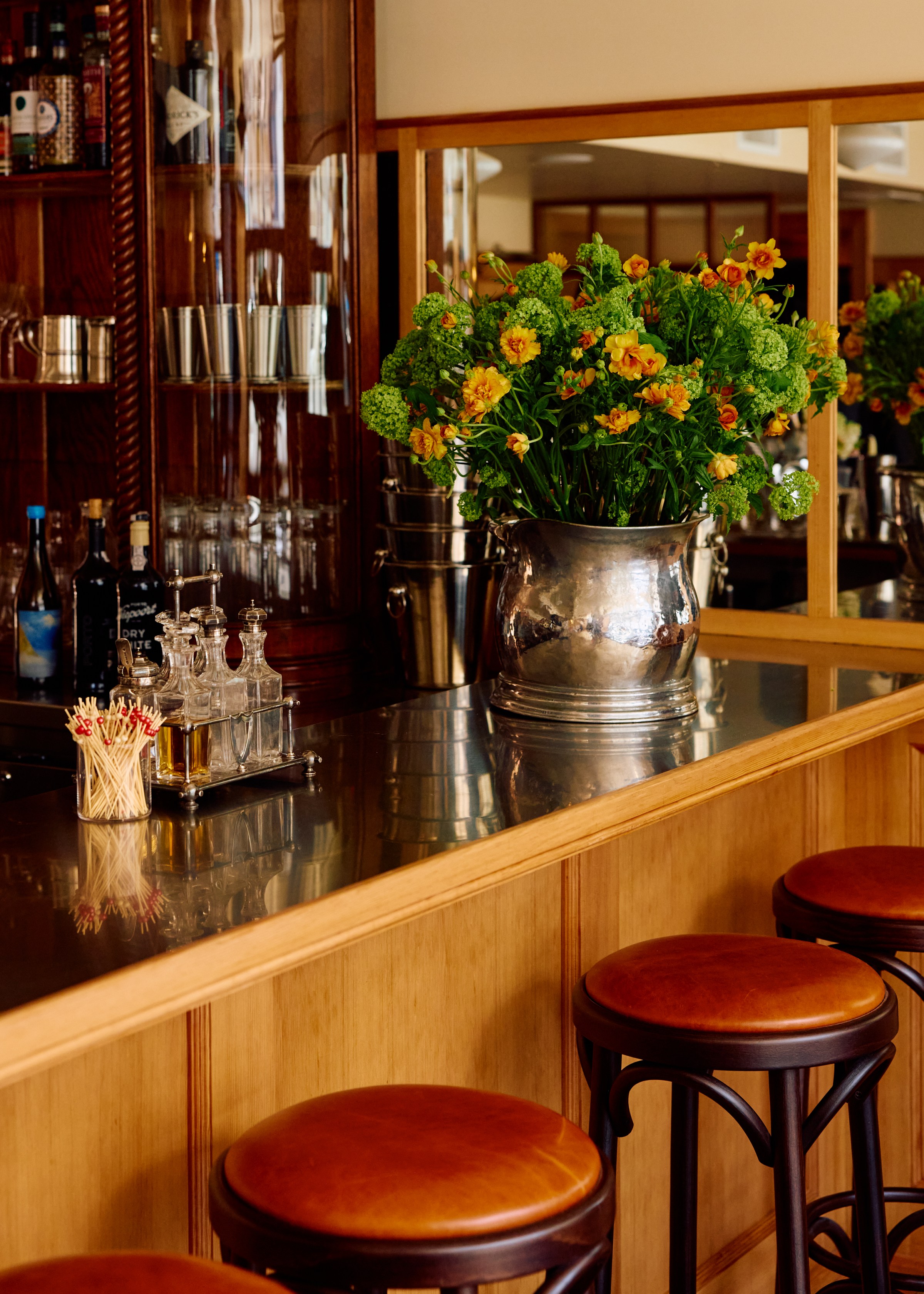 A restaurant bar with a large flower arrangement.