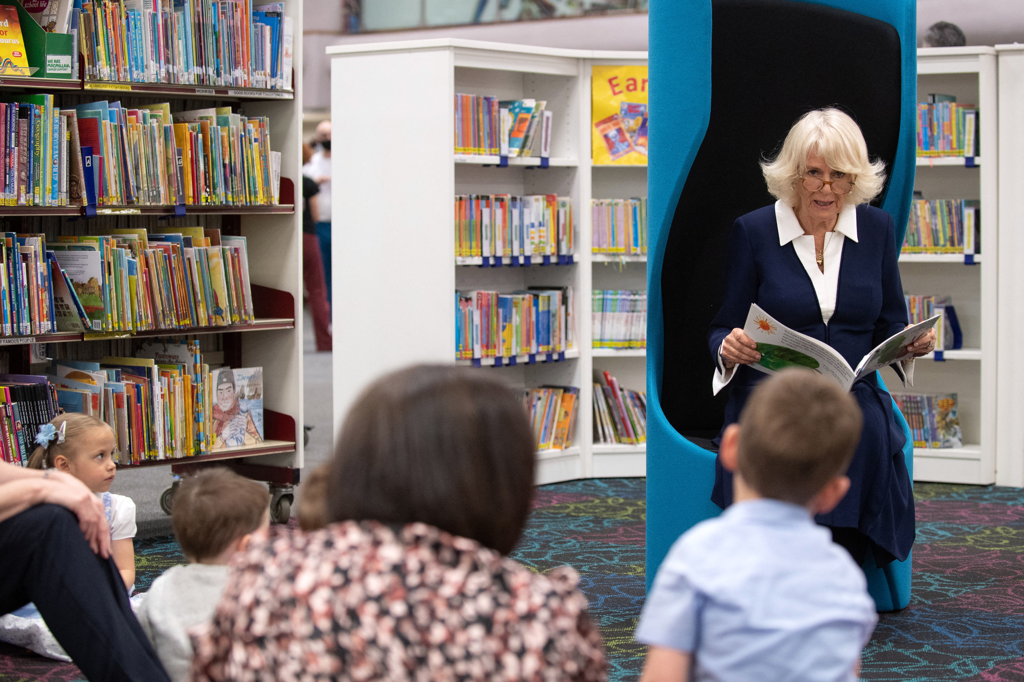 Britain&amp;apos;s Camilla, Duchess of Cornwall, wearing a face covering to combat the spread of Covid-19, reads an excerpt from the book &amp;apos; The Very Hungry Caterpillar&amp;apos; to children during her visit to Coventry Central Library in Coventry, central England on May 25, 2021. (Photo by Joe Giddens / POOL / AFP) (Photo by JOE GIDDENS/POOL/AFP via Getty Images)